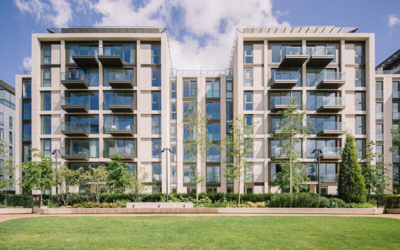 Two blocks of modern low rise buildings featuring balconies and green space to the front at Lillie Square