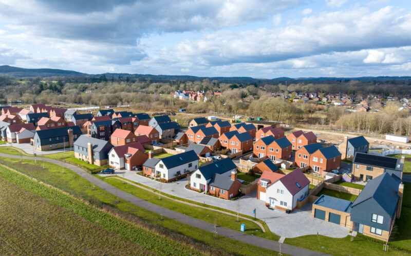Aerial view CGI of a new housing development in Cranleigh featuring lots of different house sizes and types