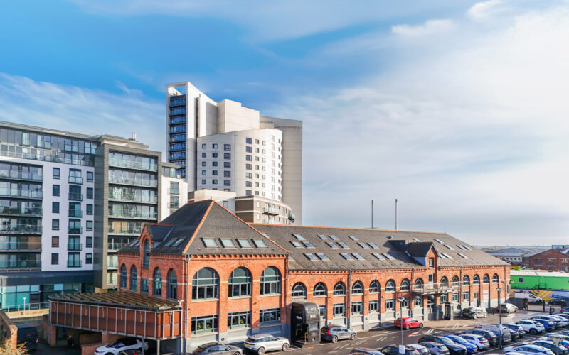 The Malthouse in Leeds is a red brick former brewery building with car parking to the front and large buildings to the rear