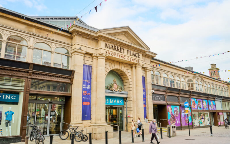 Market place shopping centre in Bolton is built in classical style and has two pillars by the front door alongside a row of modern retail units