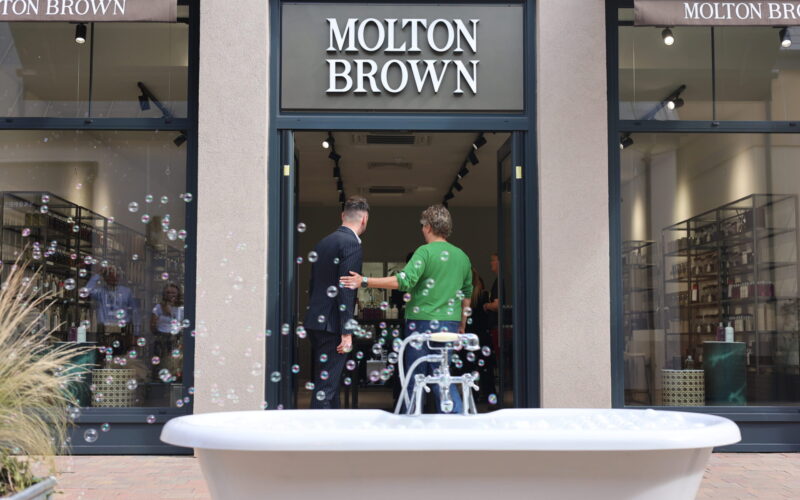 A roll top bath with bubbles rising above it in front of a Molton Brown retail unit