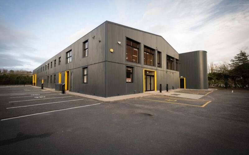 A modern low rise industrial building with a black exterior