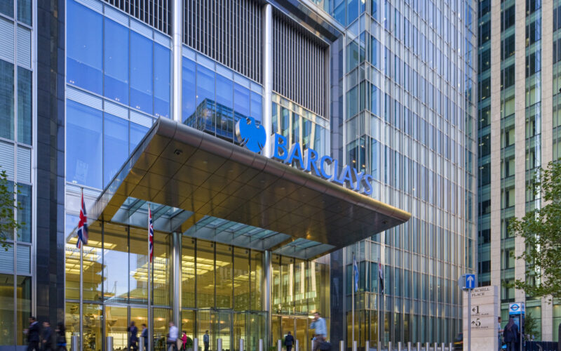 The entrance to Barclays' office headquarters at Canary Wharf with a large blue company logo above the entrance