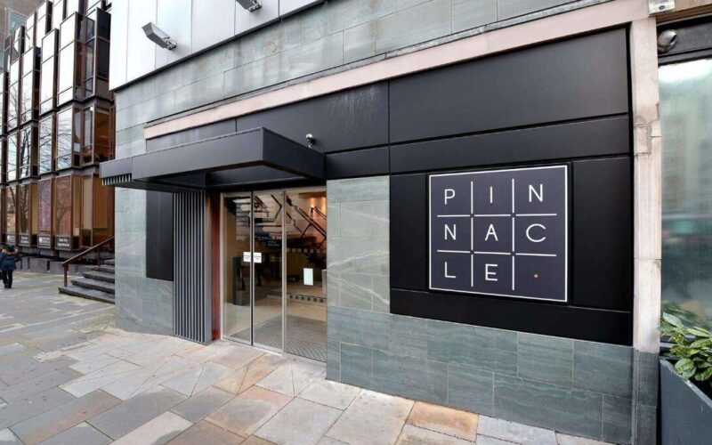 The entrance of an office building with a large Pinnacle sign