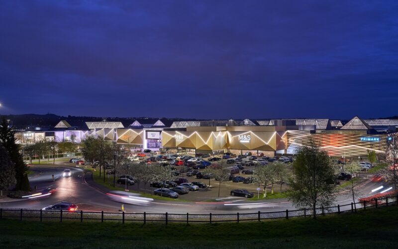 Merry Hill shopping centre at night featuring a row of retail units