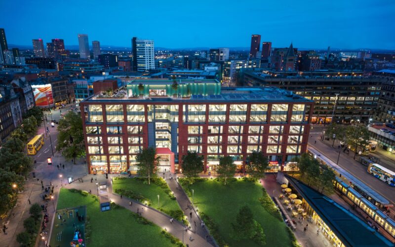 One Piccadilly Gardens is a large multi-storey office building in Manchester shown at night with green public realm at the front of the building