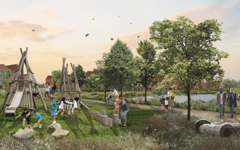 A large landscaped green area featuring trees and a lake with children playing on climbing frames and people walking on footpaths. A large housing development is in the background
