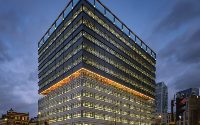 A modern multi-storey office building pictured at dusk