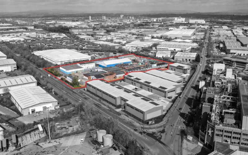 Black and white aerial view of Trafford Park industrial estate in Manchester with an area outlined in red shown in full colour