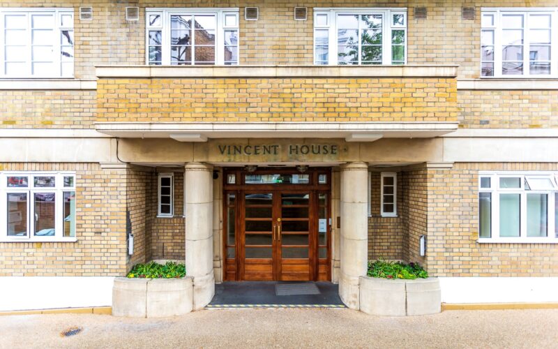 The entrance to the Art Deco inspired Vincent House in Notting Hill, which features pillars either side of brown doors