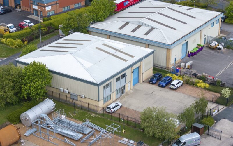 Aerial view of two industrial units with yard space and car parking to the front