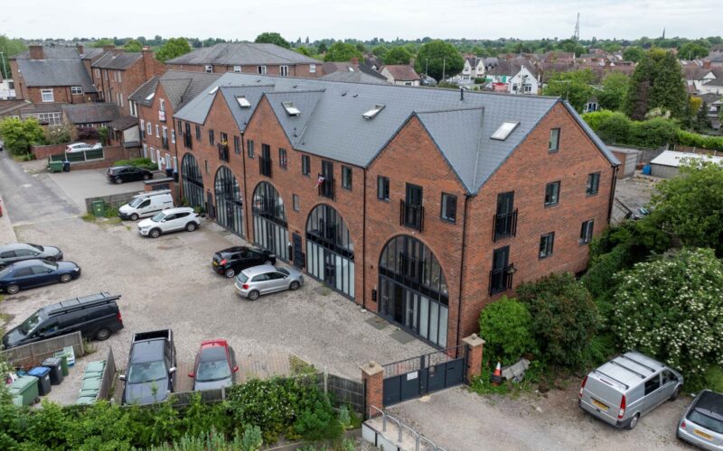 Aerial view of a brick built residential buildings with parking to the front and the side