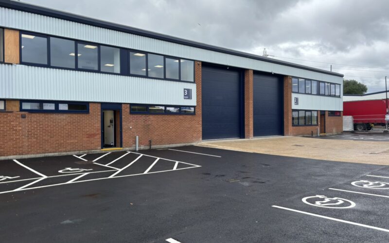 An industrial building with a parking area in front