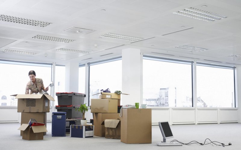 Young,Businesswoman,Unpacking,Cartons,In,An,Empty,Office,Space