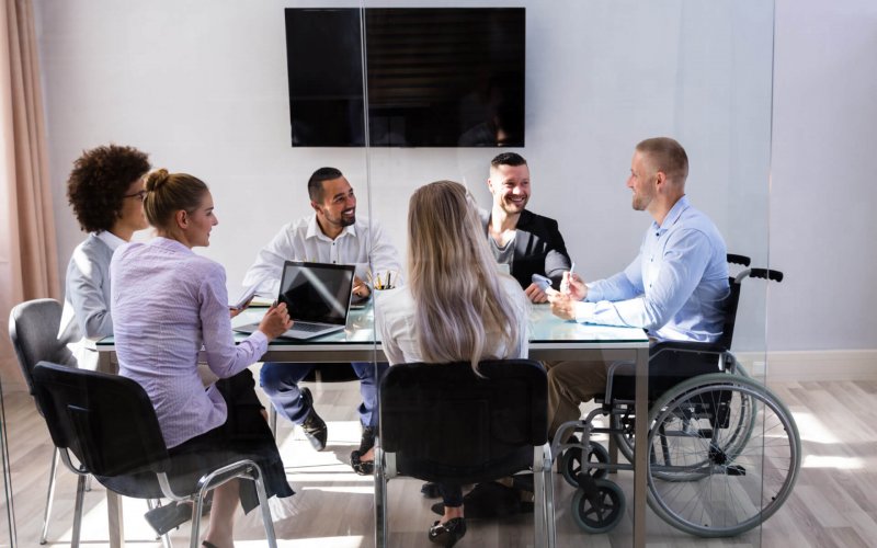 Disabled,Male,Manager,Sitting,With,His,Colleagues,At,Workplace