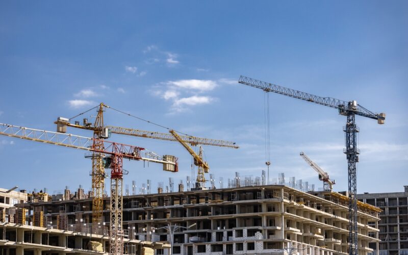 Crane,On,Construction,On,Blue,Sky,Background.,Tower,Cranes,In