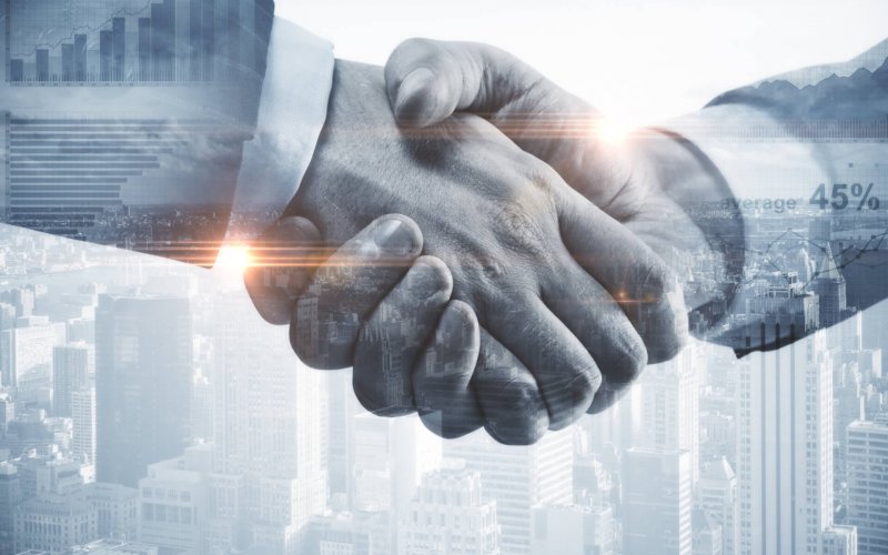 Close,Up,Of,Handshake,On,Abstract,City,Background.teamwork,Concept.,Double